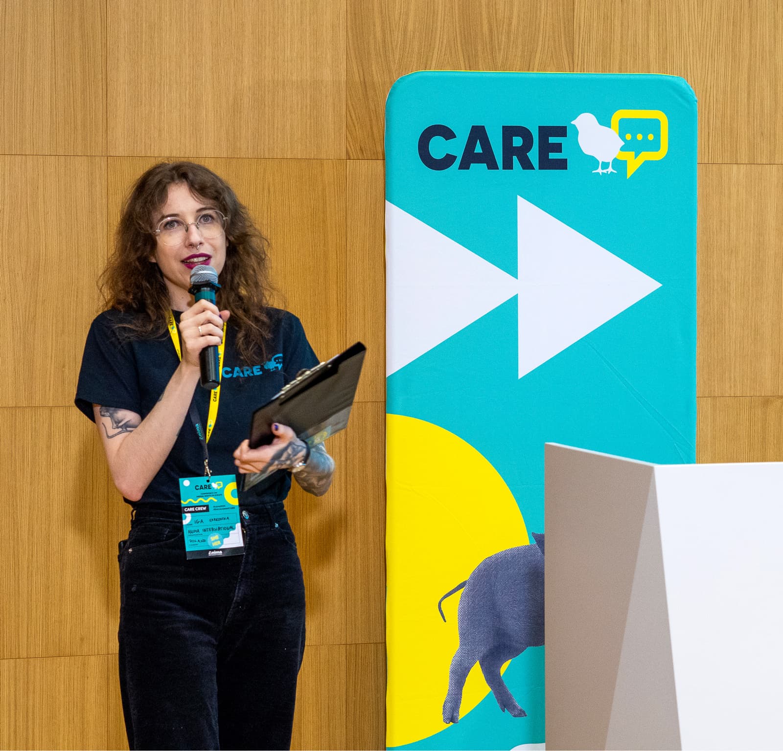 A person speaking in front of a CARE Conference logo